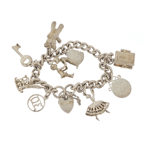 1044 - Silver charm bracelet with a selection of mostly silver charms, 56.8g