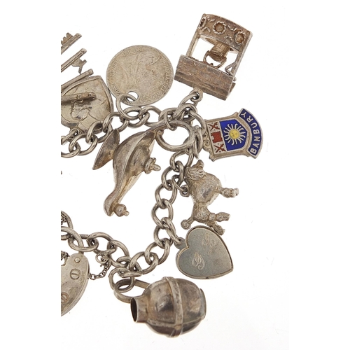 1036 - Silver charm bracelet with a selection of mostly silver charms, 49.0g