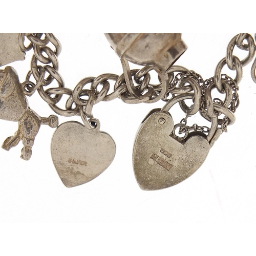 1036 - Silver charm bracelet with a selection of mostly silver charms, 49.0g