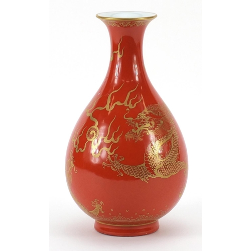 442 - Chinese porcelain iron red ground vase gilded with two dragons chasing a flaming pearl above crashin... 