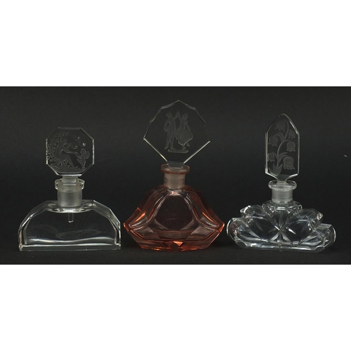 224 - Three Art Deco glass scent bottles with stoppers, each stopper etched with figures or flowers, the l... 