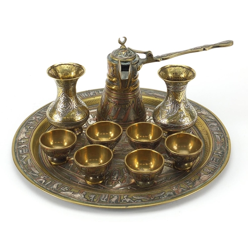 219 - Islamic brass Cairoware with silver inlay comprising coffee pot, six cups on tray and pair of vases,... 