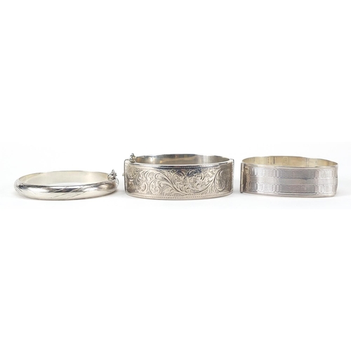 1108 - Three silver hinged bangles, two with engraved decoration, 67.0g