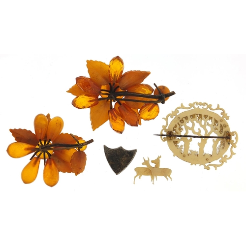 1069 - Antique jewellery comprising two amber coloured floral brooches, carved ivory brooch and a silver co... 