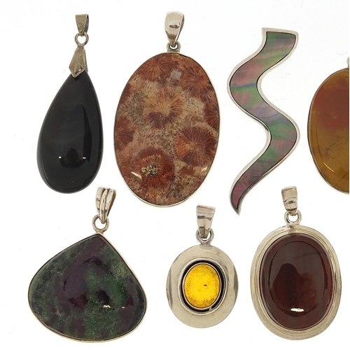 1070 - Eleven silver mounted semi precious stone pendants, the largest 5.5cm high, 104.0g