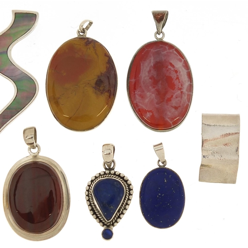 1070 - Eleven silver mounted semi precious stone pendants, the largest 5.5cm high, 104.0g