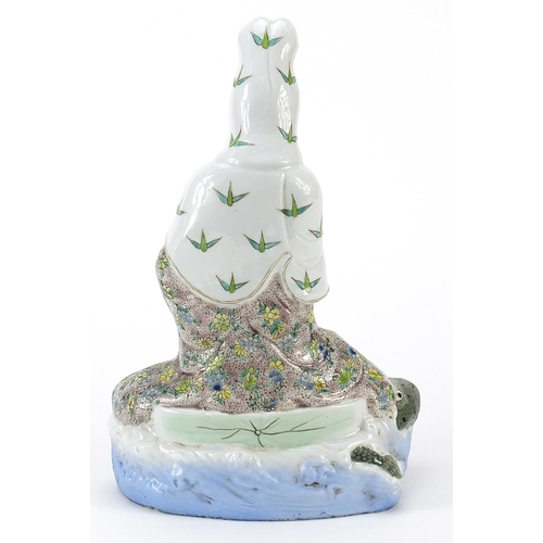 114 - Chinese porcelain figure of Guanyin riding a tortoise hand painted with flowers, 29cm high