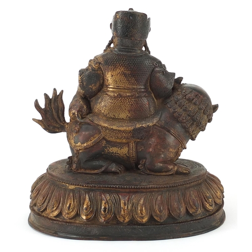 1206 - Chinese partially gilt bronzed mythical figure on an animal, 22cm high