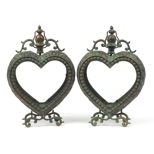 515 - Pair of ornate bronzed metal love heart candle holders with glass panels, 53cm high