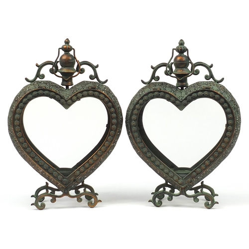 515 - Pair of ornate bronzed metal love heart candle holders with glass panels, 53cm high