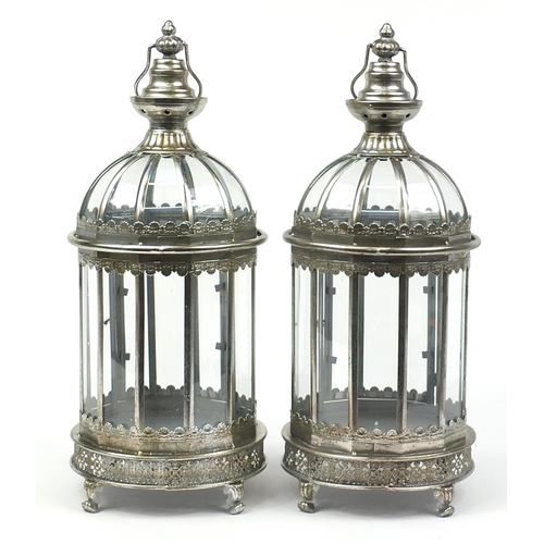 516 - Pair of ornate silvered metal lanterns with glass panels, 61cm high