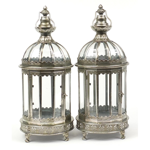 516 - Pair of ornate silvered metal lanterns with glass panels, 61cm high