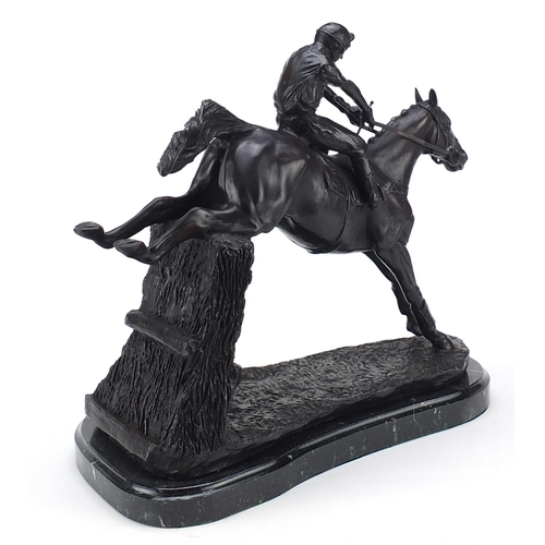 433 - Large patinated bronze jockey on horseback raised on a shaped marble base, 33cm high