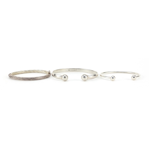 1110 - Two silver cuff bangles and a silver hinged bangle, 58.8g