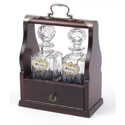 1519 - Two glass decanters housed in a mahogany tantalus with silver plated mounts, 29cm x 24.5cm W x 13cm ... 