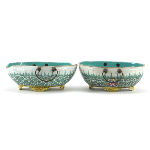19 - Two Chinese porcelain four footed bowls with metal handles, each finely hand painted with crashing w... 
