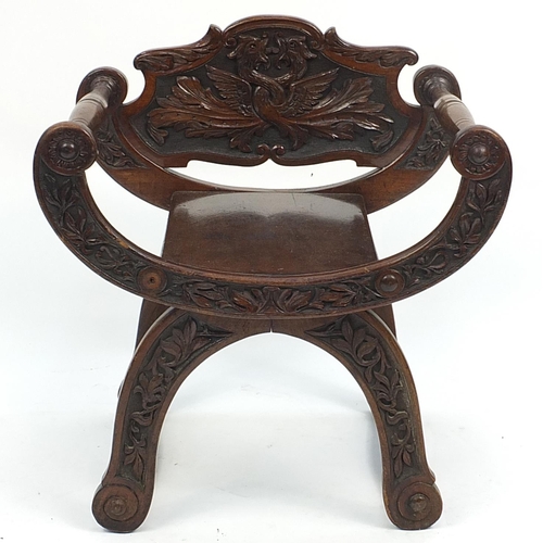 644 - Walnut X frame chair carved with mythical animals and foliage, 65cm high