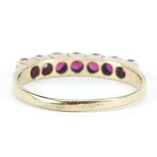 1011 - 9ct gold ruby seven stone ring, size O, 1.7g