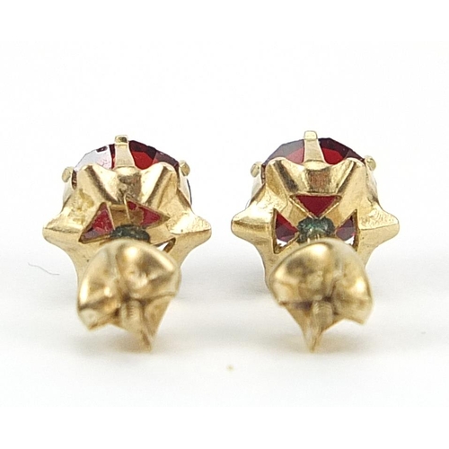 965 - Pair of 9ct gold red stone solitaire stud earrings with screw on backs, 5.4mm in diameter, 1.0g