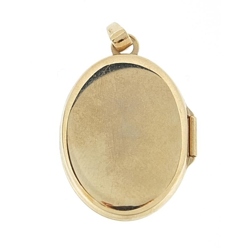 974 - 9ct gold oval locket with engraved decoration, 2.4cm high, 1.9g