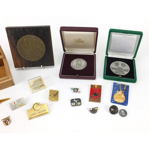 1342 - Group of hockey medals and badges, the largest 8cm in diameter