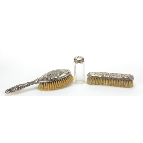 348 - Two silver mounted brushes and a cut glass jar, each embossed with Putti, various Birmingham hallmar... 