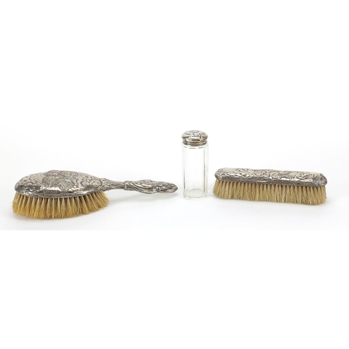 348 - Two silver mounted brushes and a cut glass jar, each embossed with Putti, various Birmingham hallmar... 