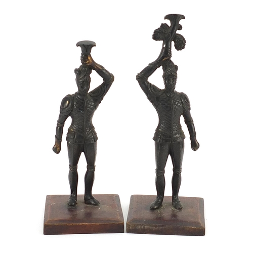 1535 - Pair of patinated spelter knights raised on square wooden bases, the largest 20cm high