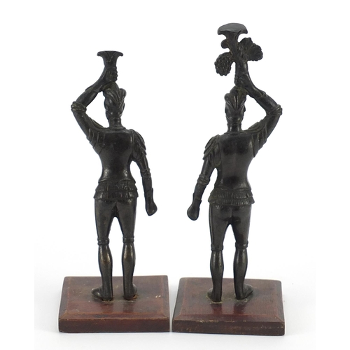 1535 - Pair of patinated spelter knights raised on square wooden bases, the largest 20cm high