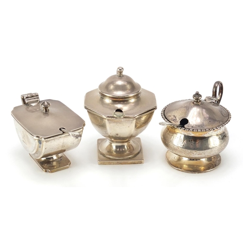 98 - Three Edwardian and later silver mustards with blue glass liners, two with silver spoons and one sil... 