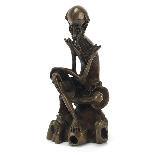 66 - Chinese patinated bronze figure of a seated skeleton man, 21.5cm high