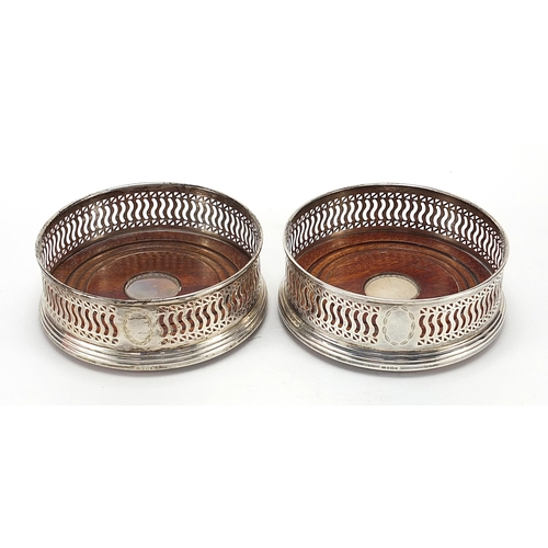 94 - W I Broadway & Co, pair of circular silver and oak wine coasters, Birmingham 1997, 12cm in diameter,... 