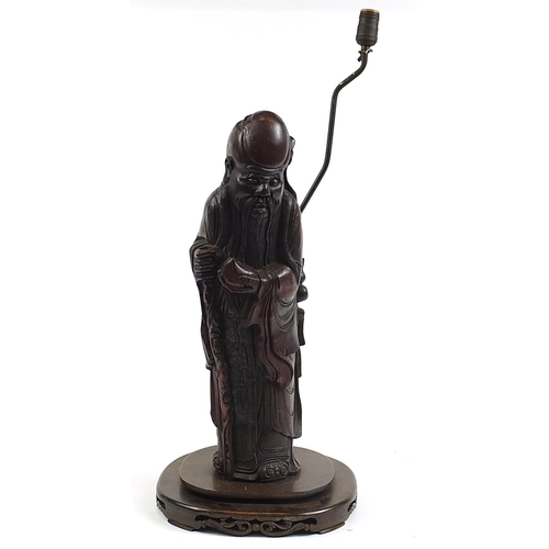452 - Chinese carved foot wood floor standing lamp in the form of an Elder holding fruit, 82cm high