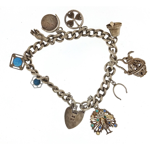 953 - Silver charm bracelet with a selection of mostly silver charms, 37.5g