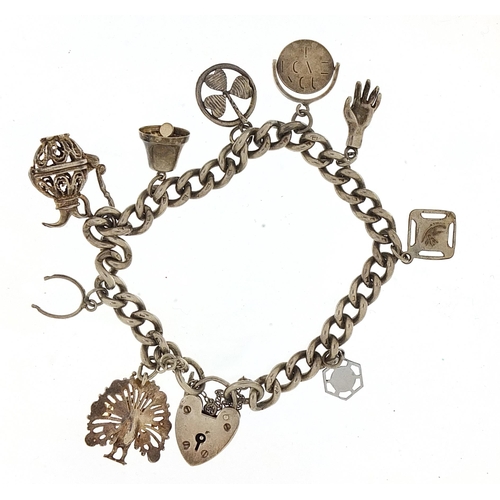 953 - Silver charm bracelet with a selection of mostly silver charms, 37.5g