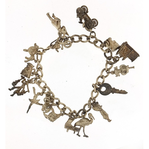 930 - Silver charm bracelet with a selection of mostly silver charms, 51.4g