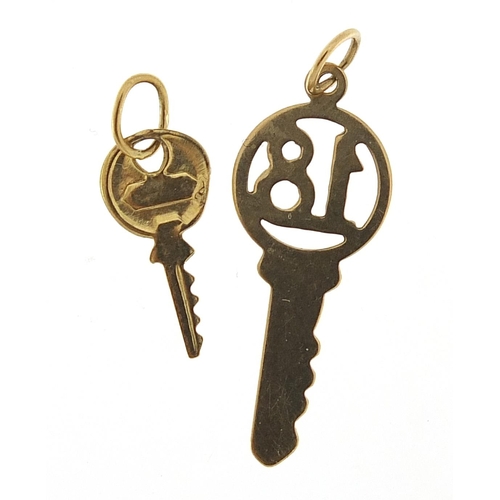 968 - Two unmarked gold key charms including no 18, the largest 2.5cm in length, total 0.7g