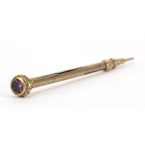 508 - Gold coloured metal propelling pencil set with an amethyst, 9.5cm in length, 6.0g