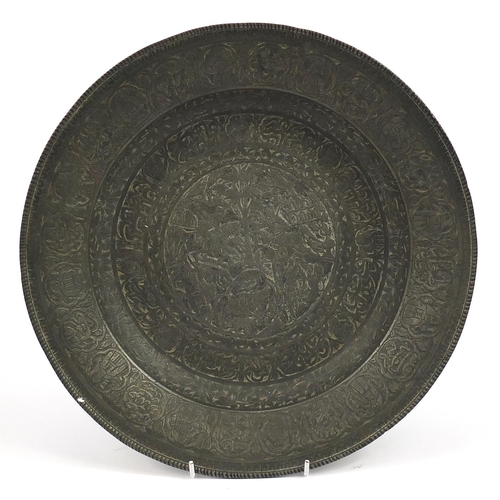 164 - Islamic Persian bronze charger engraved with figures and calligraphy, 34.5cm in diameter