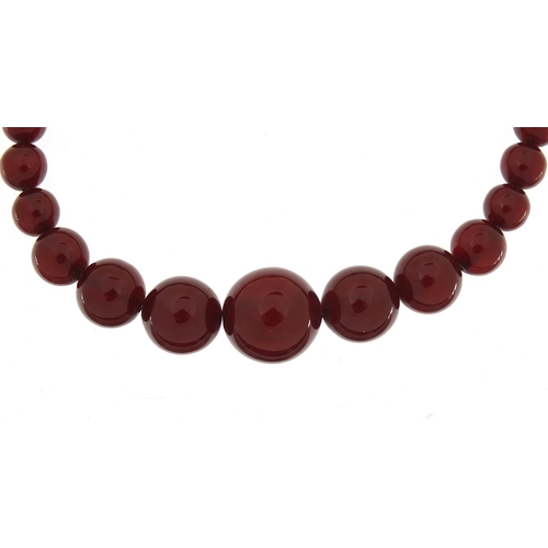 935 - Cherry amber coloured graduated bead necklace, the largest bead 1.9cm in length, the necklace 47cm i... 