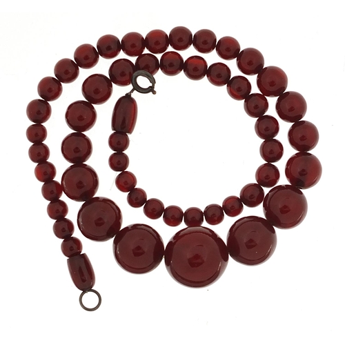 935 - Cherry amber coloured graduated bead necklace, the largest bead 1.9cm in length, the necklace 47cm i... 