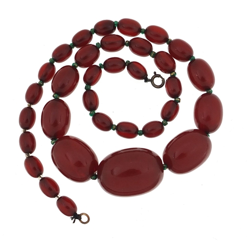 931 - Cherry amber coloured graduated bead necklace, the largest bead 2.8cm in length, the necklace 51cm i... 