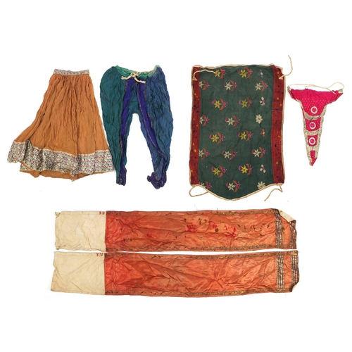 111 - Middle Eastern and Indian textiles including an embroidered skirt, Palestinian style hanging, two si... 