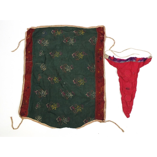 111 - Middle Eastern and Indian textiles including an embroidered skirt, Palestinian style hanging, two si... 