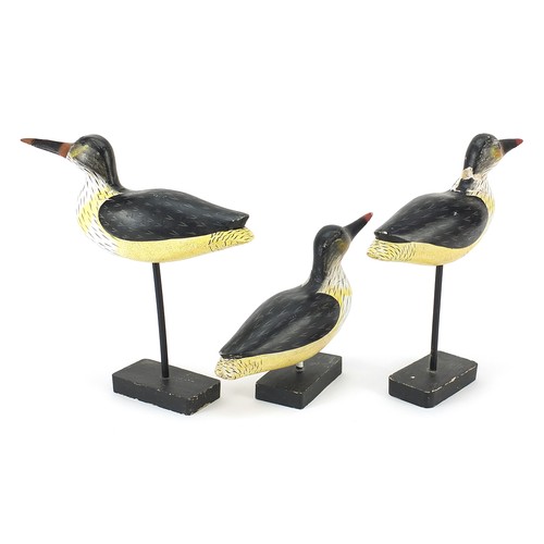 220 - Manner of Guy Taplin, three hand painted carved wood birds on stands, the largest 25.5cm high