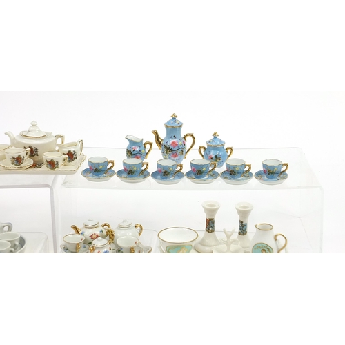 2203 - Vintage and later porcelain doll's house tea services including one decorated with flowers housed in... 