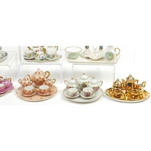 2203 - Vintage and later porcelain doll's house tea services including one decorated with flowers housed in... 