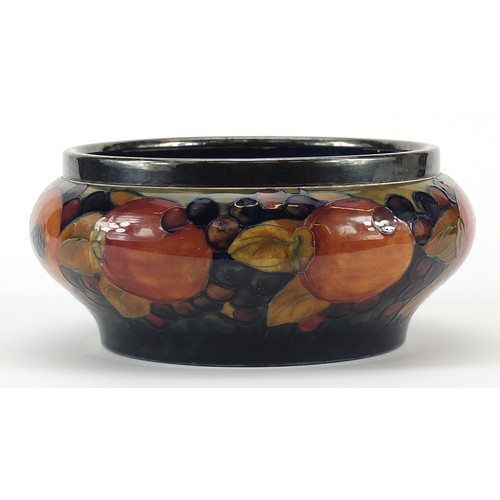 91 - William Moorcroft pottery bowl with silver plated rim hand painted with flowers, 21cm in diameter