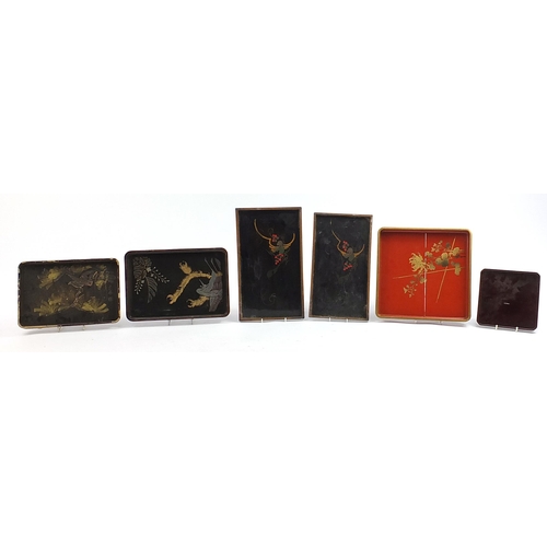 140 - Five Japanese lacquered trays hand painted with animals and flowers including a red example with sea... 