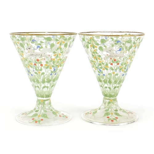 99 - Pair of Bohemian cocktail glasses in the manner of Moser, each enamelled with wild animals amongst f... 